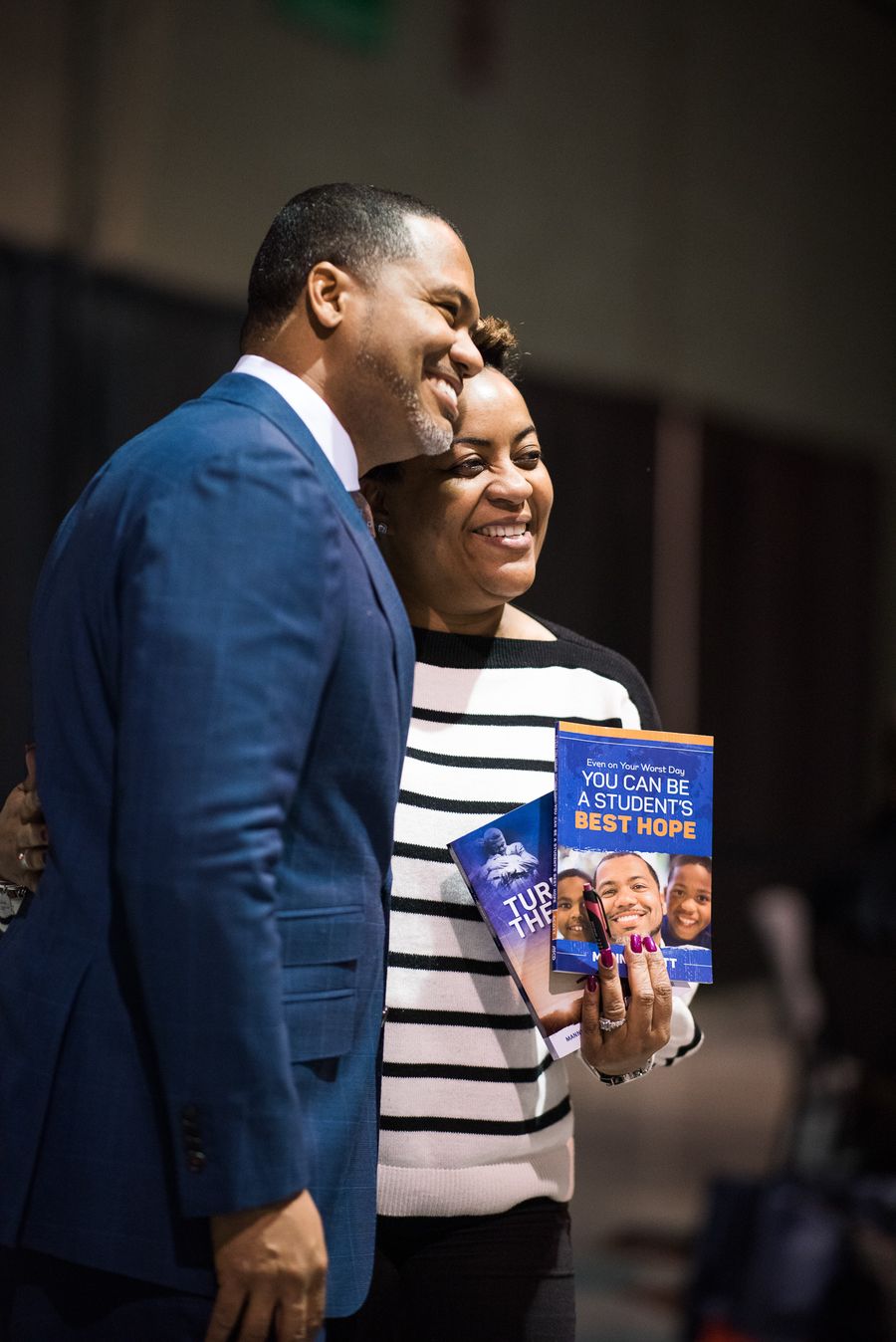 Dr. Manny Scott with an educator holding his book