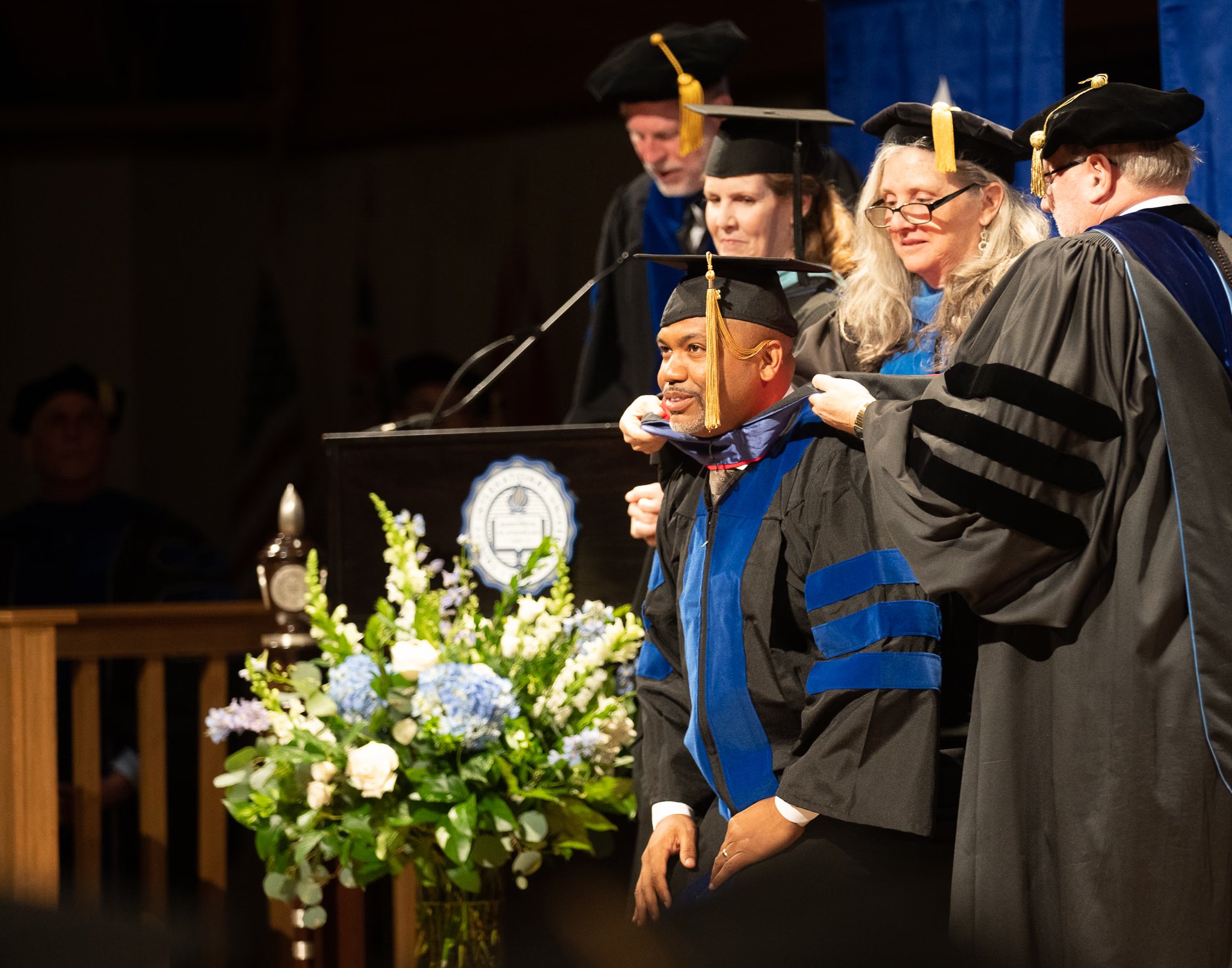 Dr. Manny Scott receiving his doctoral hood